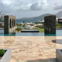 a pool with a view of the ocean and mountains in the background