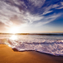 a beach with waves and a blue sky