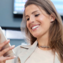 a woman smiling at her phone
