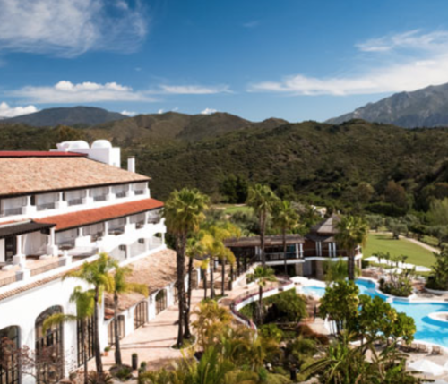 a resort with a pool and mountains in the background