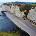 a rocky beach with a body of water and a cliff