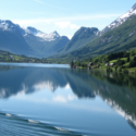 a body of water with mountains and trees