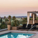 a pool with chairs and a view of a city