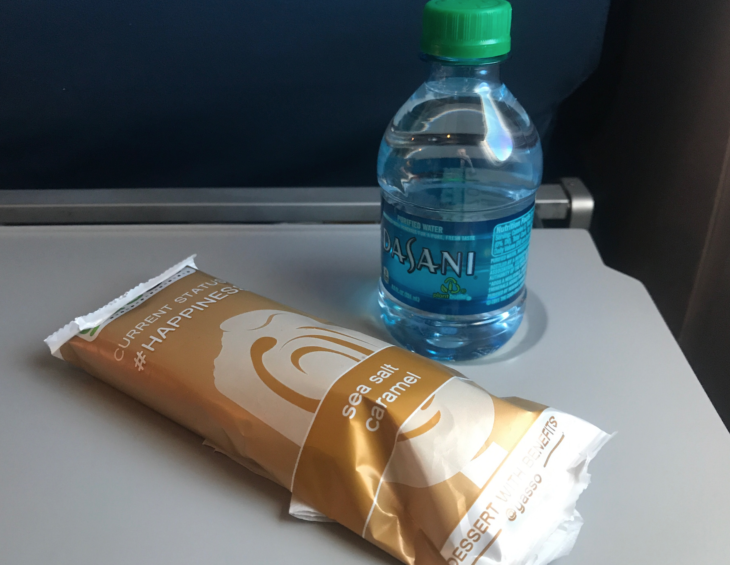 a bottle of water next to a package of caramel