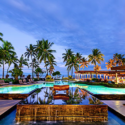 a pool with palm trees and a building