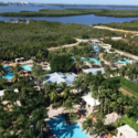 a pool in a resort surrounded by trees and water