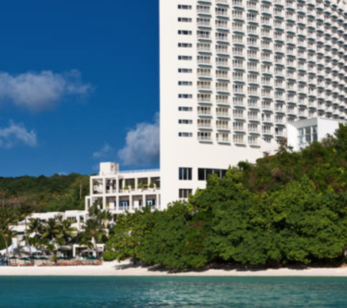 a large white building next to a body of water