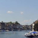 a river with boats and buildings in the background