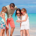 a man and woman with two girls on a beach