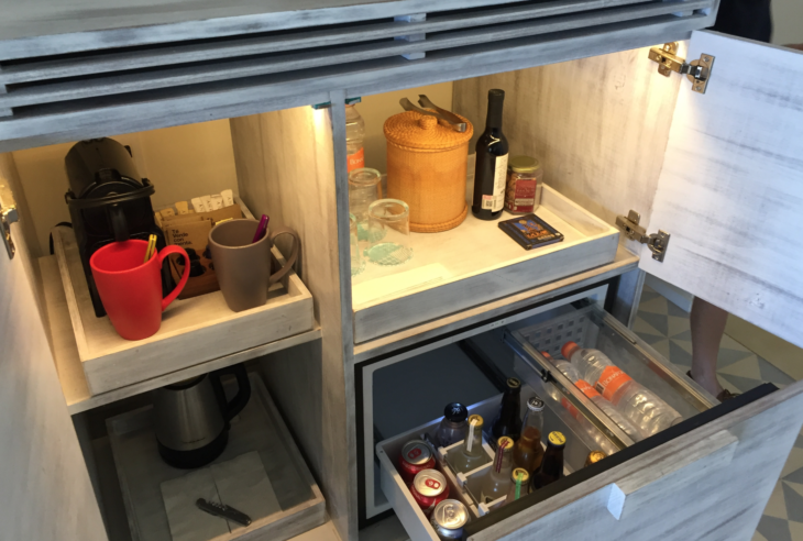 a cabinet with a drawer full of drinks and beverages