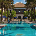 a pool with palm trees and a building