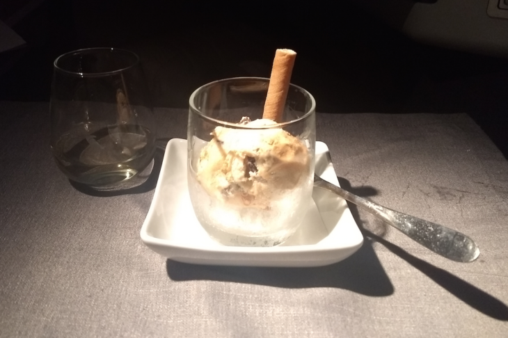 a glass of ice cream on a plate with a spoon