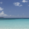 a blue ocean with a sailboat in the distance