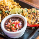 a plate of food with a bowl of salsa