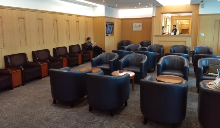 a room with chairs and a man sitting on a bench