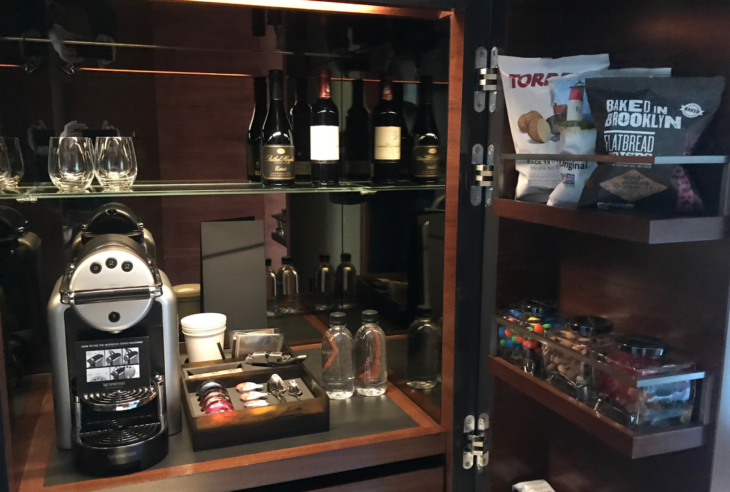 a cabinet with a shelf full of wine bottles and other items