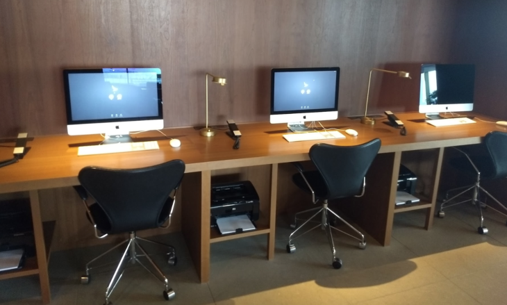 a desk with two computers and a lamp on it