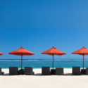 a row of chairs and umbrellas on a beach