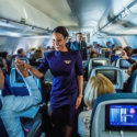 a woman in a purple dress standing in an airplane