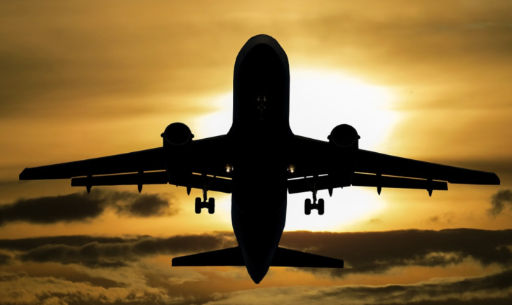 a silhouette of an airplane flying in the sky