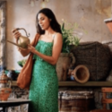 a woman in a green dress holding a jug