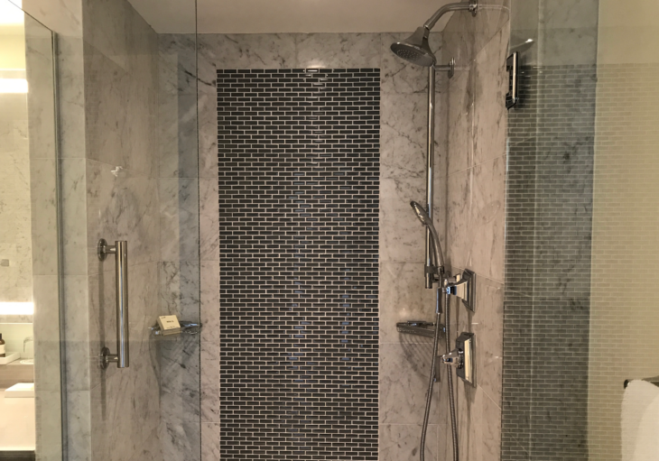 a shower with a tile wall