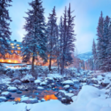a river with snow and trees in front of a building