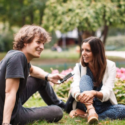 a man and woman sitting on grass