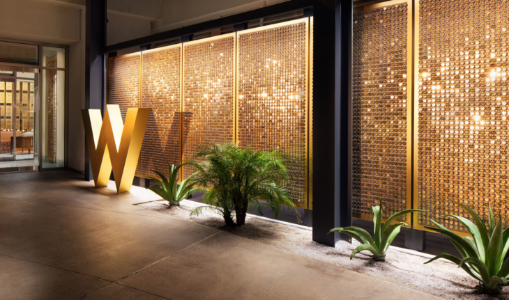 a wall with a letter and plants