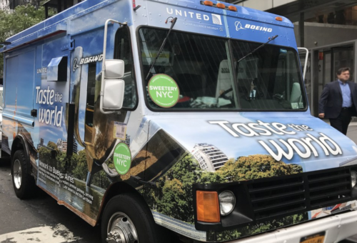 a blue truck with a green sign on it