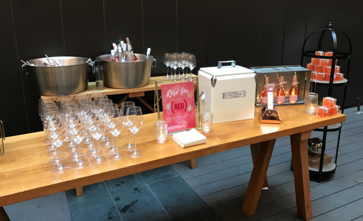 a table with wine glasses and a cooler