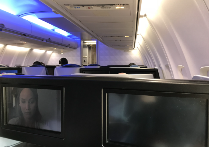 a row of seats with monitors on the side