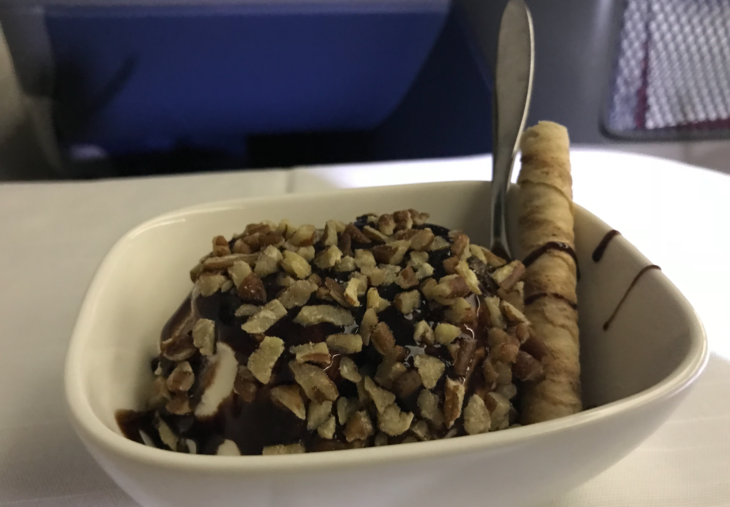 a bowl of ice cream with chocolate and nuts