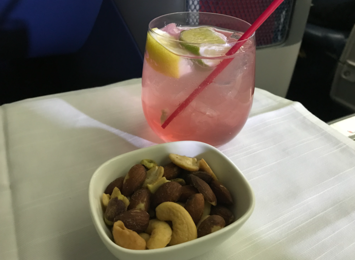 a bowl of nuts and a drink
