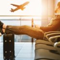 a man sitting on a luggage at an airport