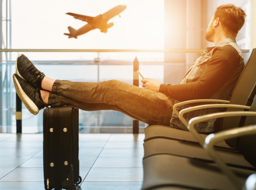 a man sitting on a luggage at an airport