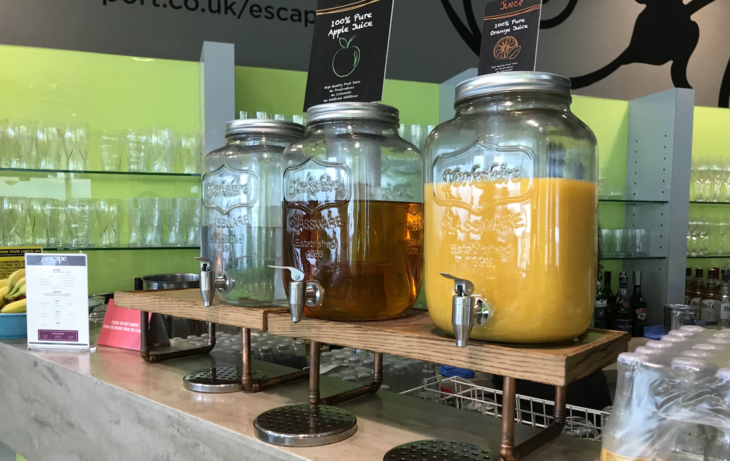 a row of juice dispensers on a counter