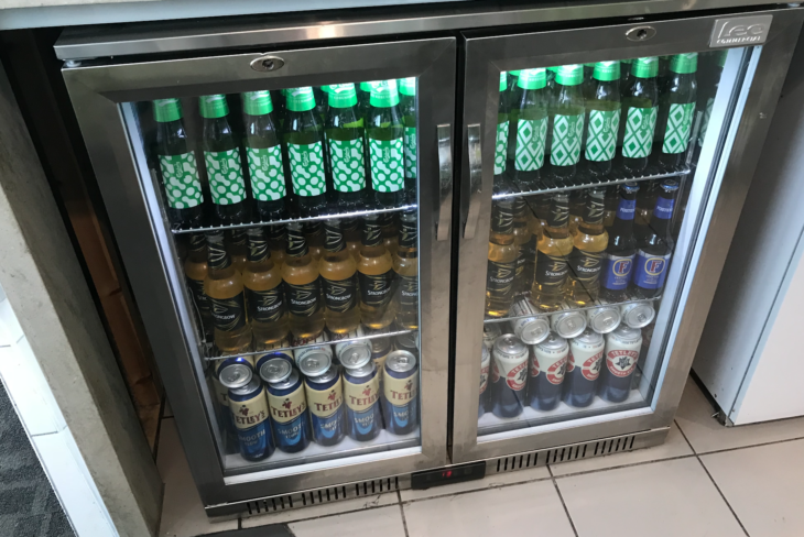 a refrigerator with bottles of beer and cans