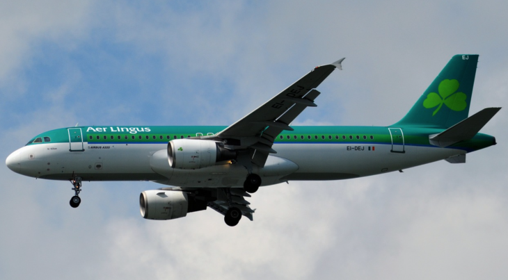a green and white airplane in the sky