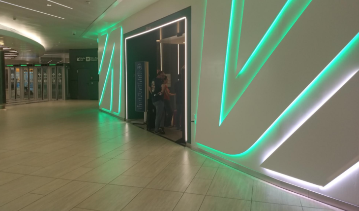 a man and woman standing in a hallway with green lights