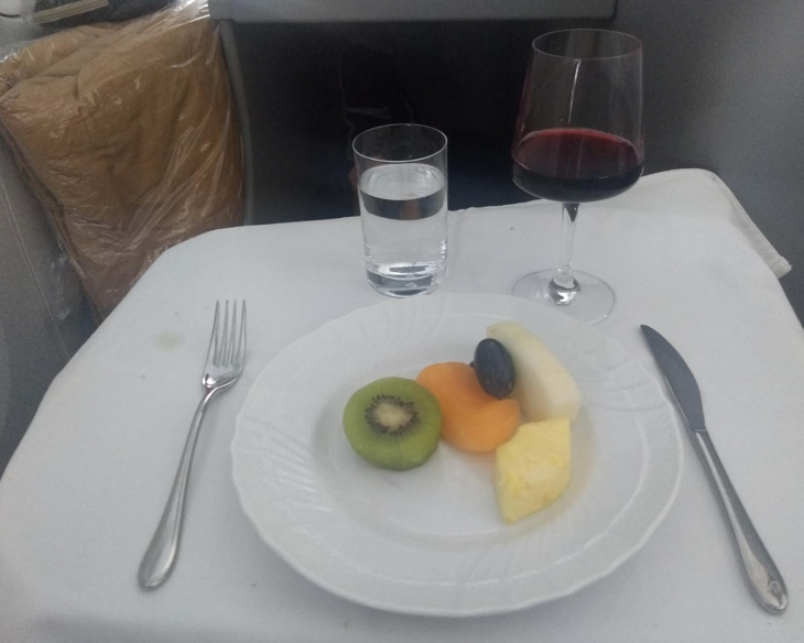 a plate of fruit and a glass of wine