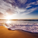 a beach with waves and a sunset