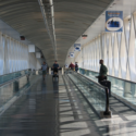 people walking on a walkway with a man and a stroller