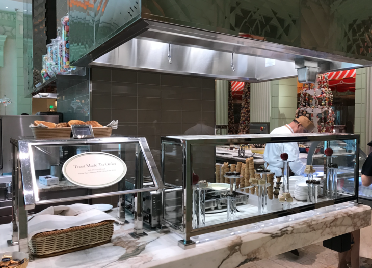 a kitchen with a counter and a man in a white coat