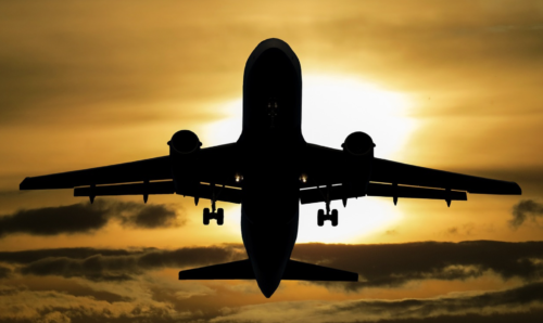 a silhouette of an airplane flying in the sky