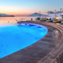 a pool with a deck and umbrellas and a dock