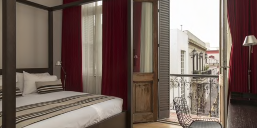a bed with a chair and a chair on a balcony
