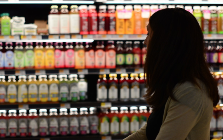 a woman standing in front of a shelf of beverages