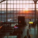 a large glass window with people walking in the airport