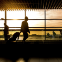 people walking in an airport with a window